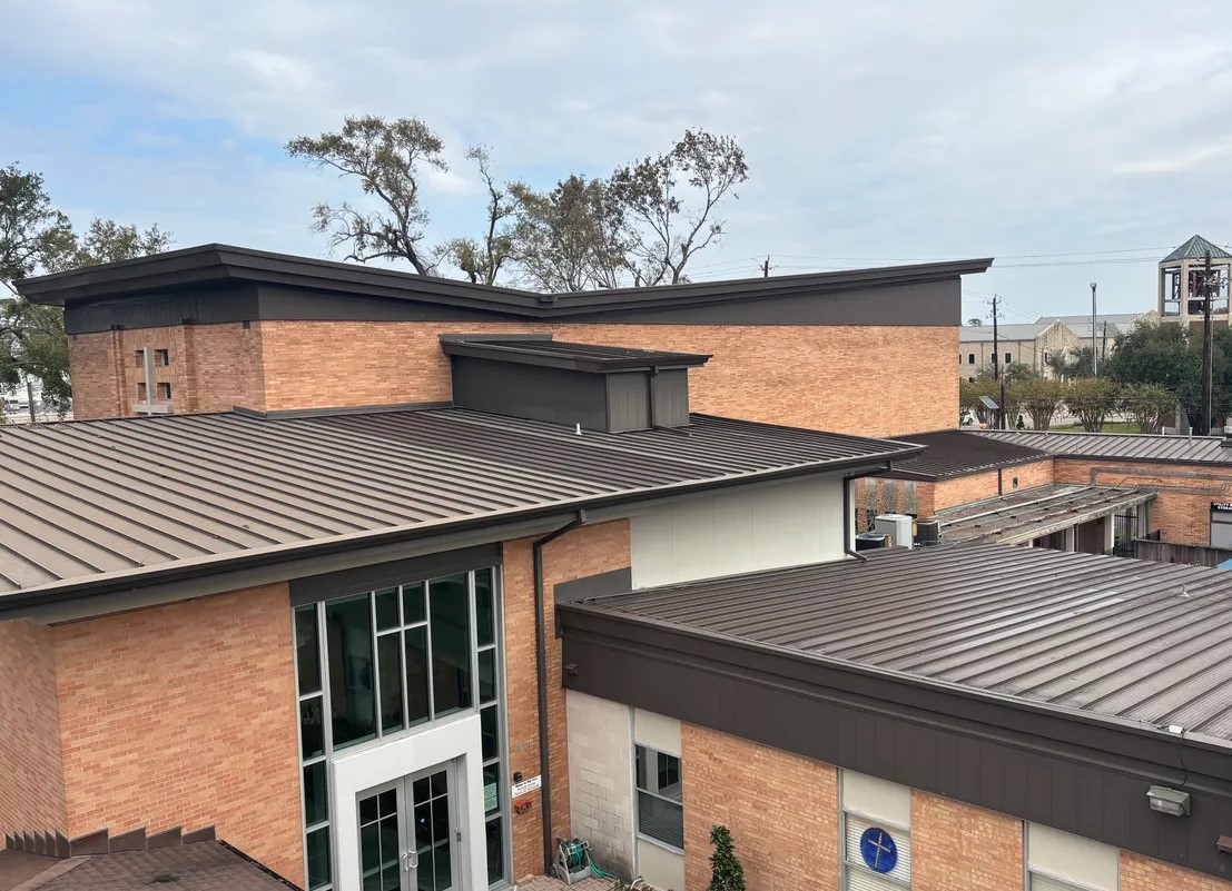 Church building with standing seam roof, brick exterior, and modern design, showcasing roofing repairs and renovations by Pride Construction & Roofing in Houston's Spring Branch neighborhood.