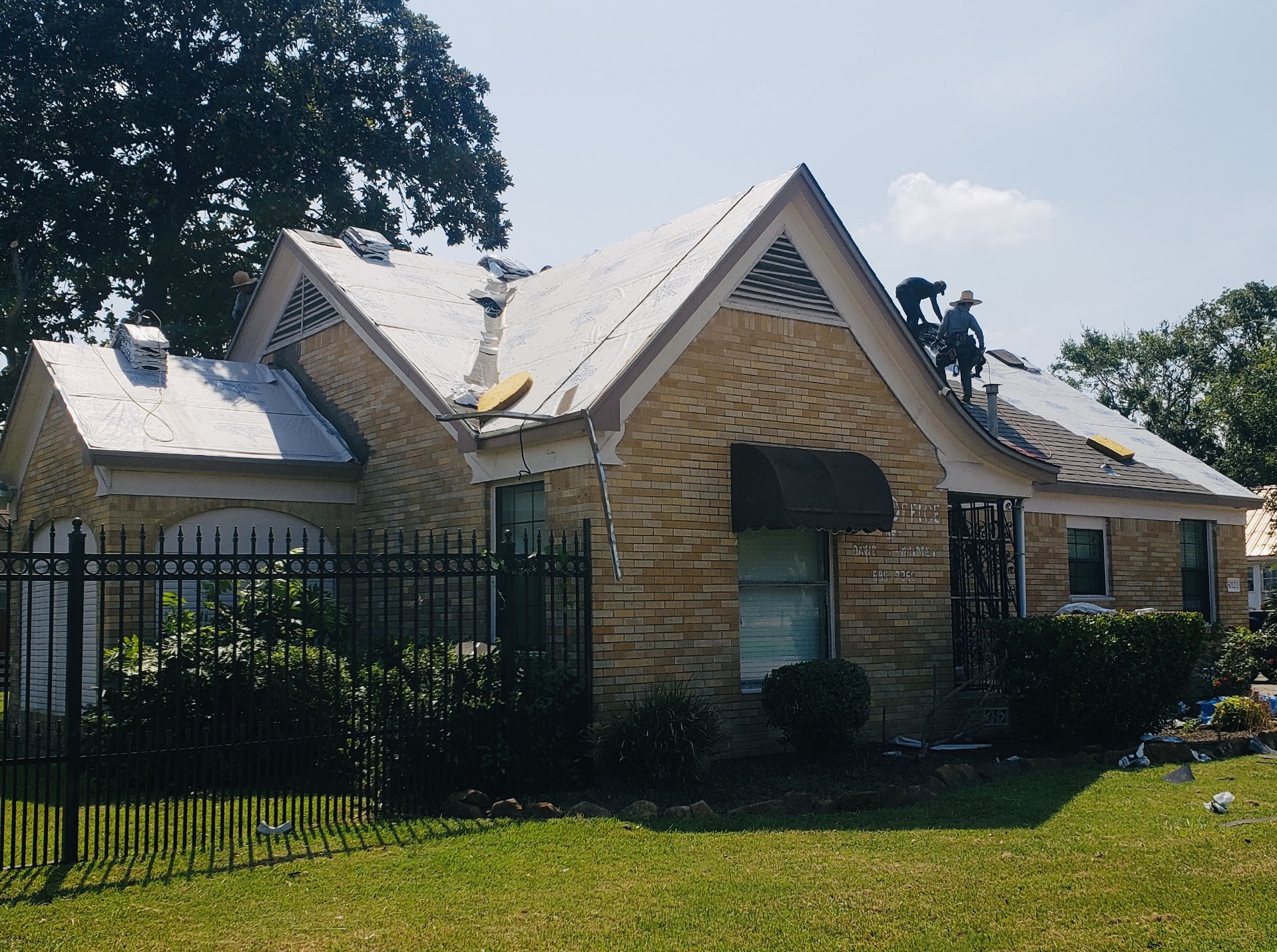Roofing professionals working on a residential roof replacement in Houston, showcasing energy-efficient materials and installation techniques by Pride Construction & Roofing.